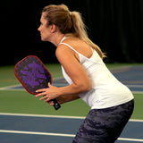Onix Graphite Evoke XL Pickleball Paddle, woman holding the paddle in a ready stance to return the serve