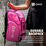 Pink Onix backpack held by a person against a chain-link fence.
