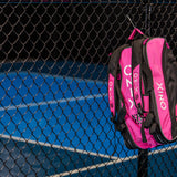 ONIX Pink Pickleball Backpack Hanging on fence